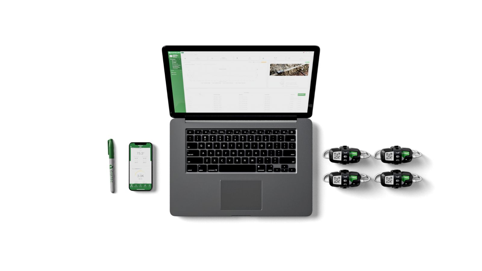 Equipo de trabajo de Giatec 360, un computador y un teléfono con la plataforma abierta junto a cuatro sensores SmartRock