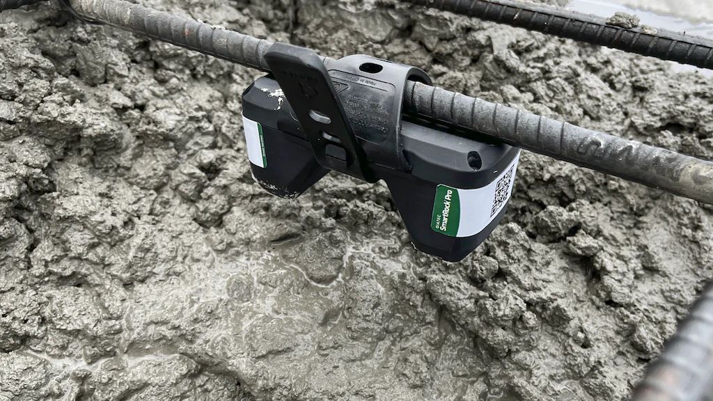 Sensor SmartRock Pro amarrado a la enfierradura y rodeado de hormigón recién colocado en una obra